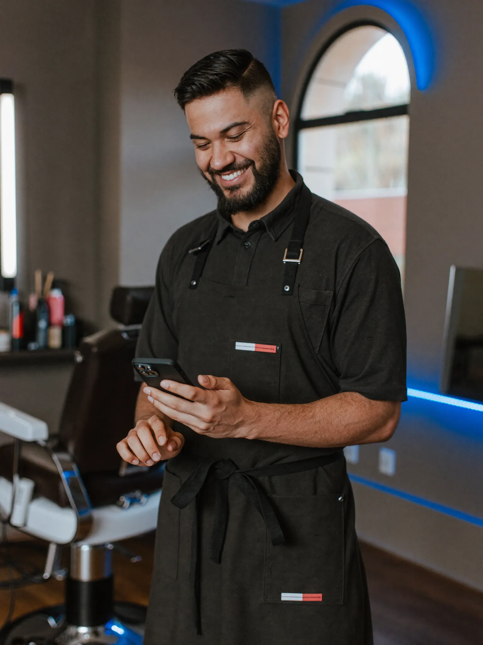 Barbero peruano revisando su WhatsApp mientras el bot agenda las citas
